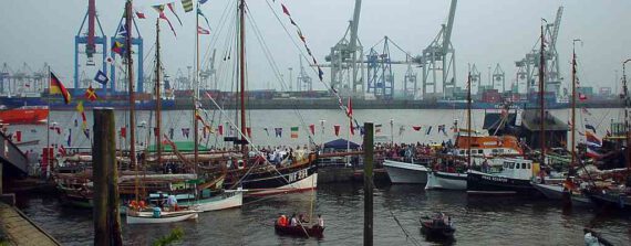 Museumshafen mit vielen Schiffen am Lieger und Kränen auf der anderen Elbseite