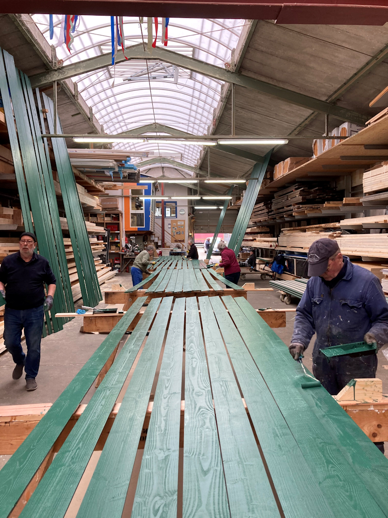 Die Fassadenbretter für die Außenwand werden gestrichen